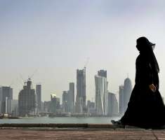 una mujer de Qatar camina delante del horizonte de la ciudad en Doha .  /  AP