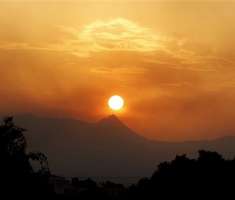 El sol se pone mientras el humo de los incendios forestales se rezaga en el pueblo de Benitachel, cerca de Valencia.  /  Foto: AP