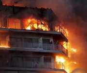 Dos personas aguardan en el balcón a ser rescatadas en el incendio declarado sobre las cinco y media de esta tarde en un quinto piso de un edificio de viviendas de València. EFE