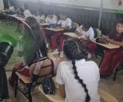 Aulas de clases improvisadas y abanicos para soportar el calor en una escuela de Herrera..