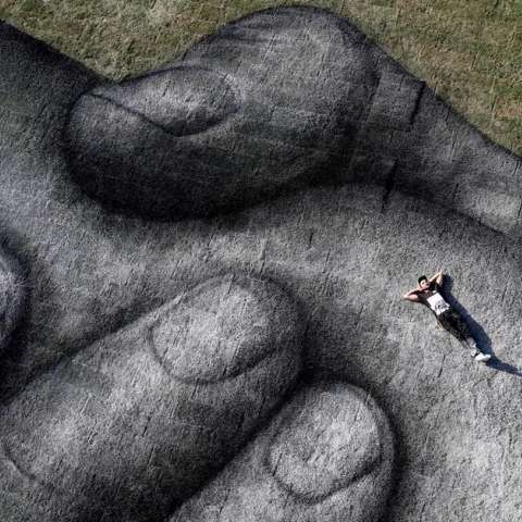  El artista franco-suizo Saype posa en su propia pintura biodegradable titulada &#039;detrás de los proyectos del muro&#039; en un espacio flotante en el estrecho del Bósforo en Estambul, Turquía.