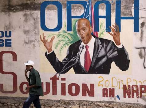 Fotografía de archivo de un hombre camina junto a un mural en homenaje al asesinado expresidente Jovenel Moise, en Puerto Príncipe (Haití). EFE