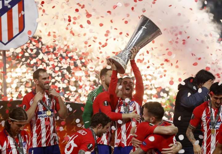 Antoine Griezmann (c) de Atlético Madrid sostiene el trofeo junto a sus compañeros hoy. Foto: EFE
