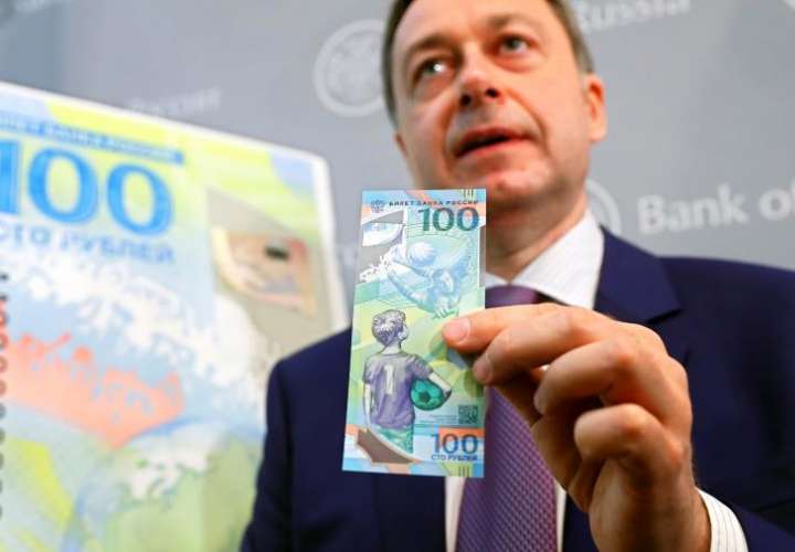 El director general de Goznak, empresa que se dedica a la producción de billetes y monedas en Rusia, Arkady Trachuk, presenta un billete de 100 rublos especial con motivo de la celebración del próximo Mundial de Fútbol 2018, en Moscú. Foto EFE
