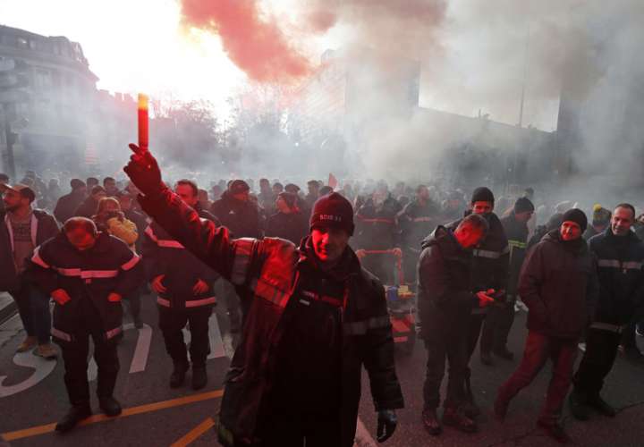 Un bombero enciende una bengala roja durante la huelga nacional liderada por los sindicatos franceses contra la reforma gubernamental del sistema de pensiones, en Toulouse. EFE Archivo