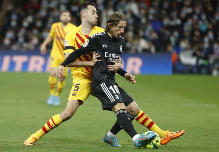 Luka Modric (d) protege un balón ante Sergio Busquets. Foto: EFE