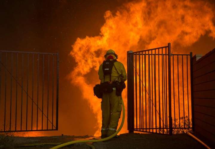 Un bombero trata de apagar un incendio hoy, jueves 9 de agosto de 2018, en Corona, California (EE.UU.). EFE