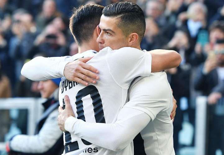 Cristiano Ronaldo (der.) celebra uno de sus goles con su compañero Paulo Dybala. Foto: AP