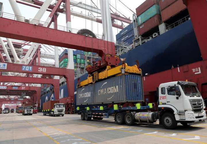 Foto de archivo de un camión mientras descarga un contenedor en el puerto de Qingdao (China). EFEArchivo