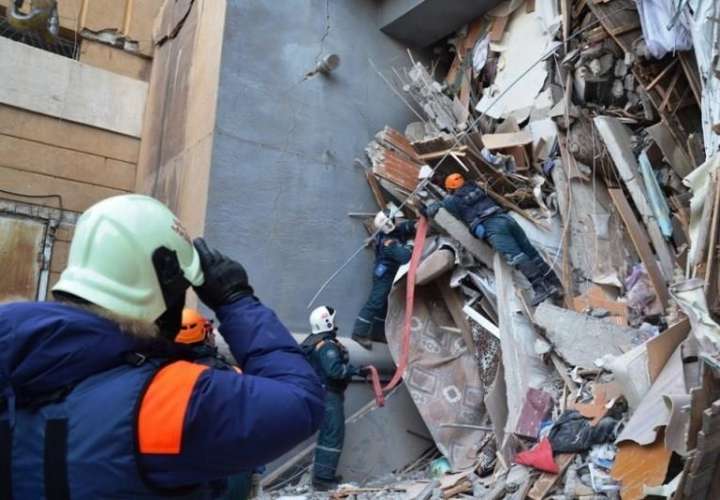 Miembros de los servicios de rescate rusos retiran escombros de un edificio derrumbado el lunes en la ciudad de Magnitogorsk, en la región de los Urales (Rusia). EFE