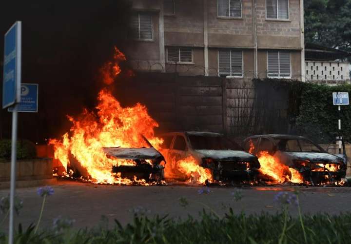 Vista de tres coches en llamas tras una serie de explosiones cerca de un complejo hotelero en Nairobi, Kenia. EFE