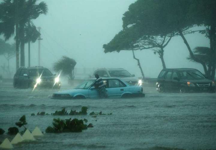 Vehículos fueron registrados este miércoles al circular bajo la intensa lluvia, durante el paso de la tormenta tropical Fred, sobre Santo Domingo (República Dominicana). EFE