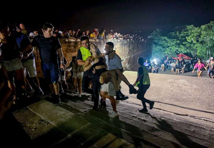 Unos hombres cargan a una mujer afectada tras un tiroteo registrado en un evento musical, hoy, en San Bernardino (Paraguay). EFE