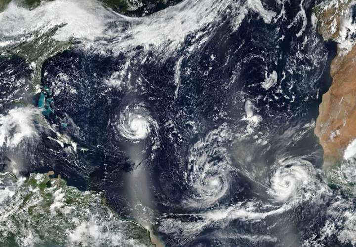 Imagen facilitada por la NASA que muestra los huracanes (i-d) Florence, Isaac y Helene avanzando por aguas del Atlántico Norte. EFE