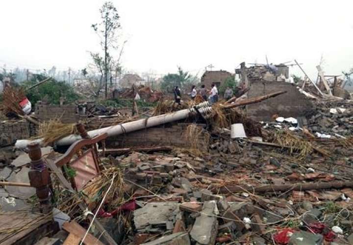 Los residentes pasan casas destruidas en las secuelas de un tornado que sacudió el distrito de Funing, en la ciudad de Yancheng en la provincia oriental china de Jiangsu.  /  Foto: AP