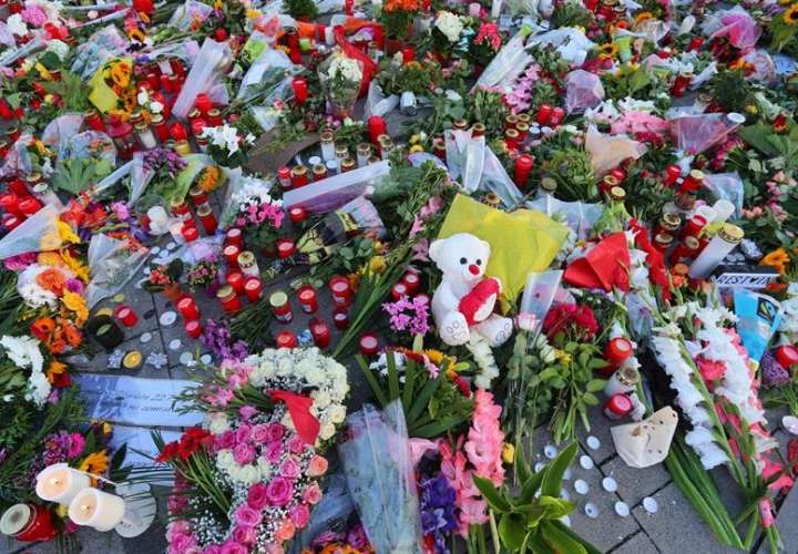 Flores, velas y peluches despositadas en la entrada del centro comercial de Múnich en el que el pasado viernes un joven mató a nueve personas y posteriormente se suicidó.  / Foto: EFE