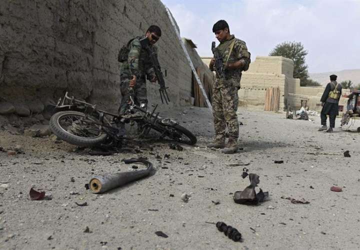 Miembros de las fuerzas de seguridad afganas inspeccionan una motocicleta destruida como parte de una operación contra militantes del Daesh (acrónimo del EI en árabe) en Khot, Afganistán, el pasado martes.  / Foto: EFE