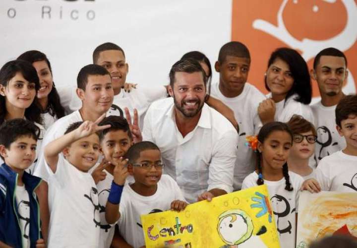  El cantante Ricky Martin posa con varios estudiantes durante la inauguración este lunes 25 de agosto del Centro educativo construido gracias a la aportación de la Fundación Ricky Martin y aliados. Thais Llorca EFE