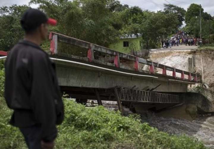 Los residentes están de pie delante de un puente derribado por el huracán Earl en el barrio de Arroyito , en Melchor de Mencos , Guatemala.  /  Foto: AP