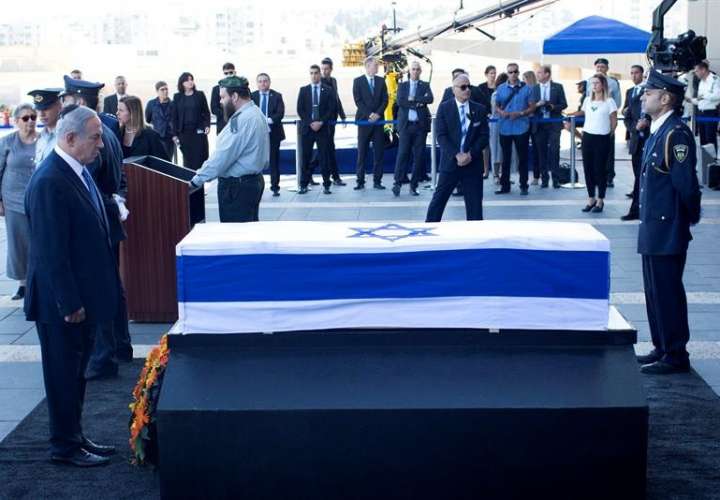 El primer ministro de Israel Benjamin Netanyahu (C) rinde sus respetos ante el féretro del que fue ex presidente y ex primer ministro israelí y premio Nobel de la Paz, Simon Peres, en el Parlamento (Knesset) hoy, 29 de septiembre. /  Foto: EFE
