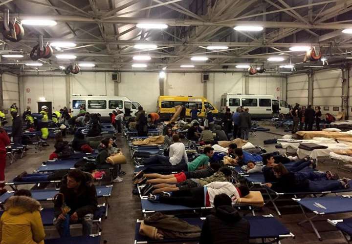 Docenas de personas evacuadas por los terremotos, pasan la noche en un hangar de autobuses convertido en refugio temporal, en Camerino, Italia.  /  Foto: EFE