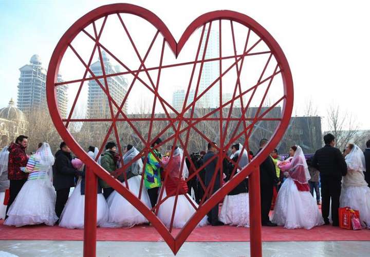 Parejas asisten a una ceremonia de bodas masiva en el 33º Festival Internacional de Hielo y Nieve de Harbin en Harbin, provincia de Heilongjiang, (China) hoy, viernes 6. EFE