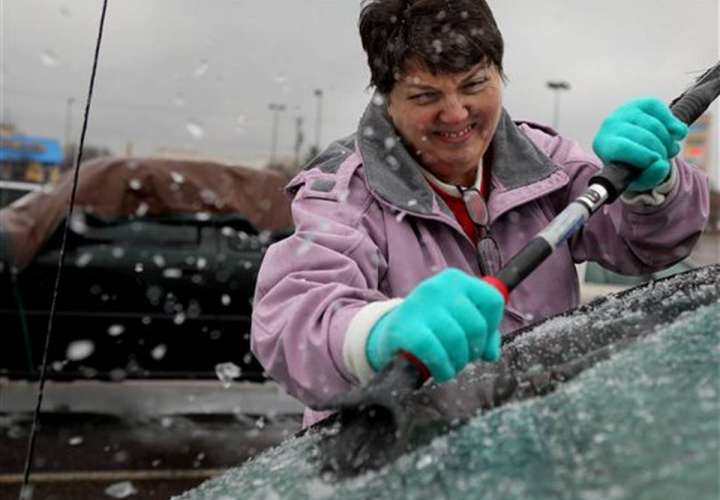 Mary Zinser retira el hielo acumulado en el parabrisas de su vehículo el viernes 13 de enero de 2017 en Arnold, Missouri.  /  Foto: AP