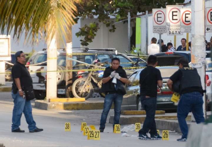 Investigadores de la policía trabajan en la escena del crimen donde un tiroteo estalló después de un ataque contra el edificio de la Fiscalía del Estado de Quintana Roo, en Cancún, México.  / Foto: AFP