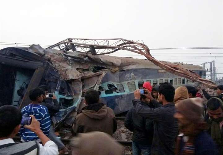 Varias personas toman fotografías con sus teléfonos en el lugar del accidente de un tren Aimer-Sealdah Express que descarriló el 28 de diciembre de 2016, en Kanpur (India). EFE/Archivo