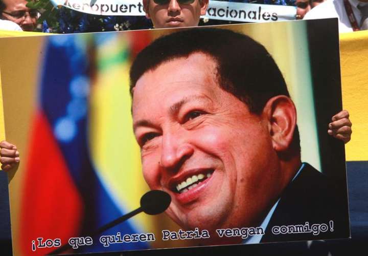 Un joven muestra un cartel con la imagen de Hugo Chávez en Managua (Nicaragua), en aniversario de su fallecimiento. EFE/Archivo