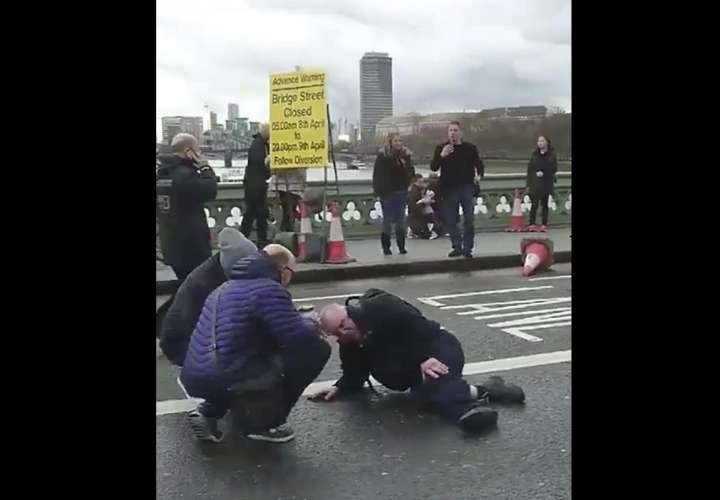 Captura de vídeo que muestra a varias personas mientras atienden a un herido tras un tiroteo en el Wetminster Bridge junto al Parlamento en Londres, Reino Unido, hoy, 22 de marzo de 2017.  EFE
