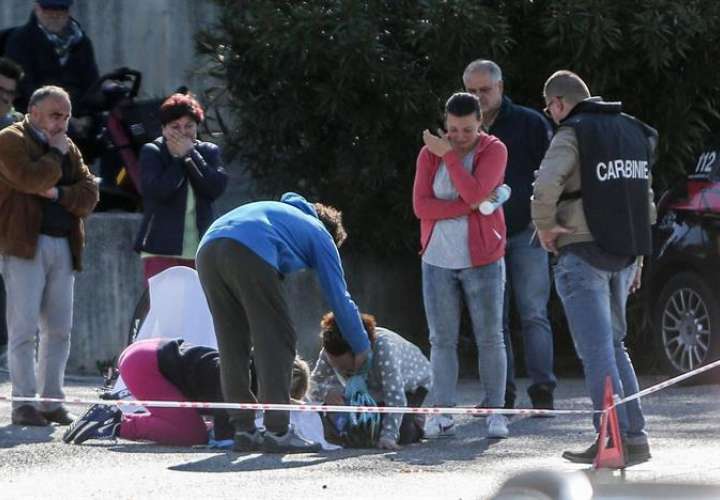 Varias personas arropan el cuerpo sin vida del ciclista italiano después del accidente de tráfico. Foto EFE