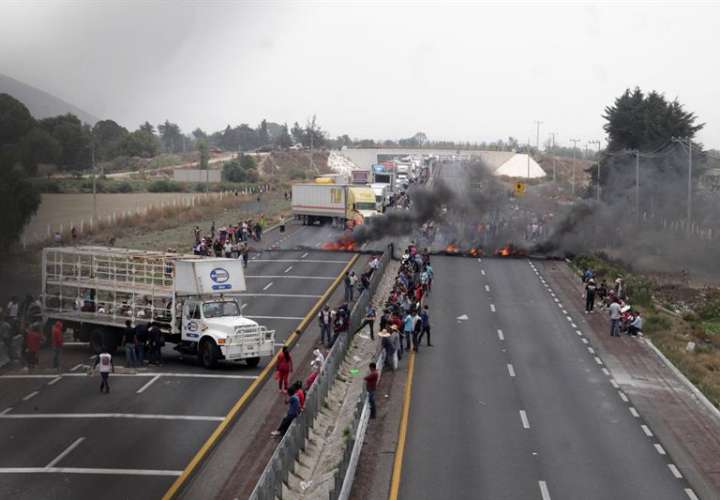 Vista general de habitantes del poblado del Palmarito durante un bloqueo de la autopista tras enfrentamientos.  /  Foto: EFE