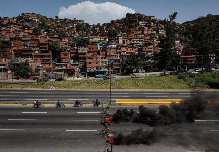 Vista general de una barricada en llamas durante una protesta antigubernamental hoy, lunes 26 de junio de 2017, en Caracas (Venezuela).