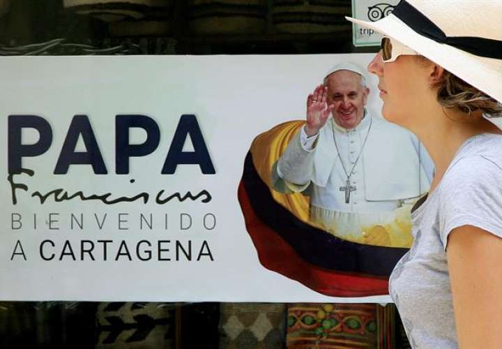 Una mujer camina frente a un cartel con la imagen del papa Francisco en Cartagena (Colombia). EFE