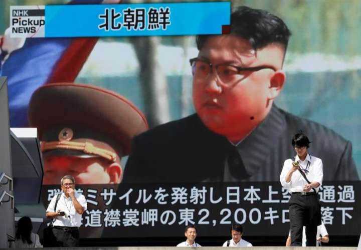 Los peatones caminan bajo un monitor a gran escala que muestra al líder norcoreano Kim Jong-un en una emisión de noticias de televisión hoy, viernes 15 de septiembre, en Tokio (Japón). EFE