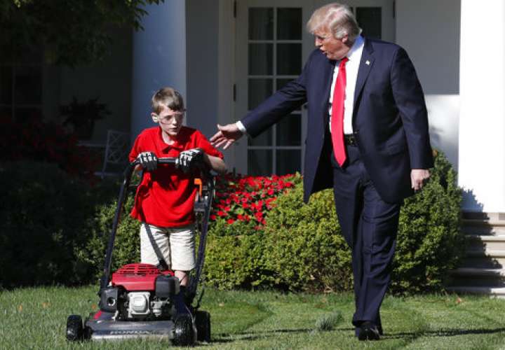 El presidente Donald Trump saluda a Frank Giaccio, de 11 años, mientras poda el jardín de la Casa Blanca, el viernes 15 de septiembre de 2017.  /  Foto: AP