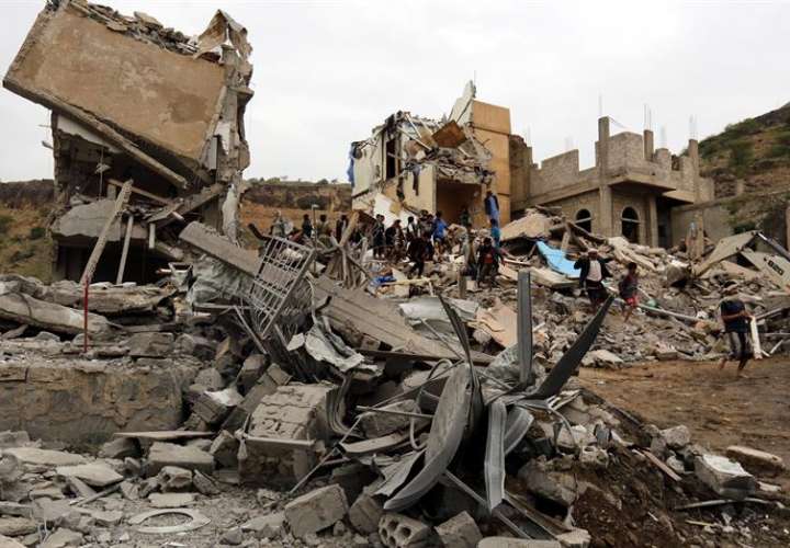 Varios yemeníes inspeccionan los restos de un edificio tras un bombardeo en Saná (Yemen). EFE/Archivo