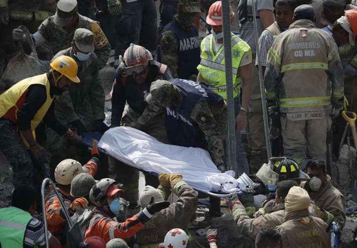Brigadistas y voluntarios rescatan cuerpos de los edificios colapsados ayer durante un sismo de magnitud 7,1 en la escala de Richter.  /  EFE