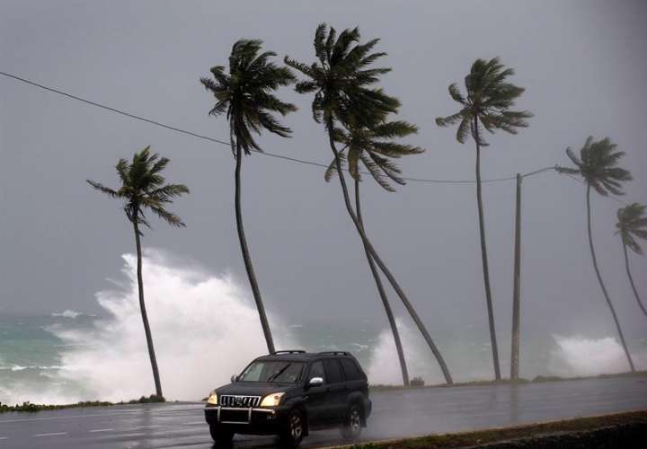Un vehículo transita cerca a la playa que presenta oleaje fuerte hoy, tras el paso del huracán María en Santo Domingo (República Dominicana).  EFE