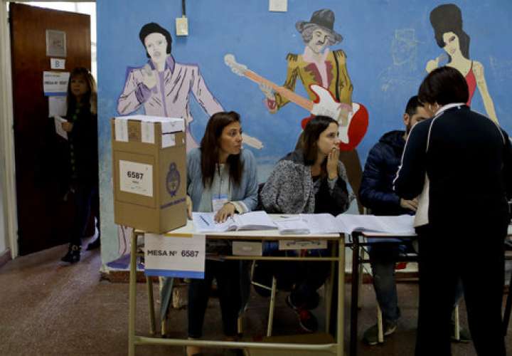 Un votante presenta sus documentos a los trabajadores electorales antes de ingresar a una cabina de votación durante las elecciones legislativas de mitad de período en Buenos Aires, Argentina. / AP