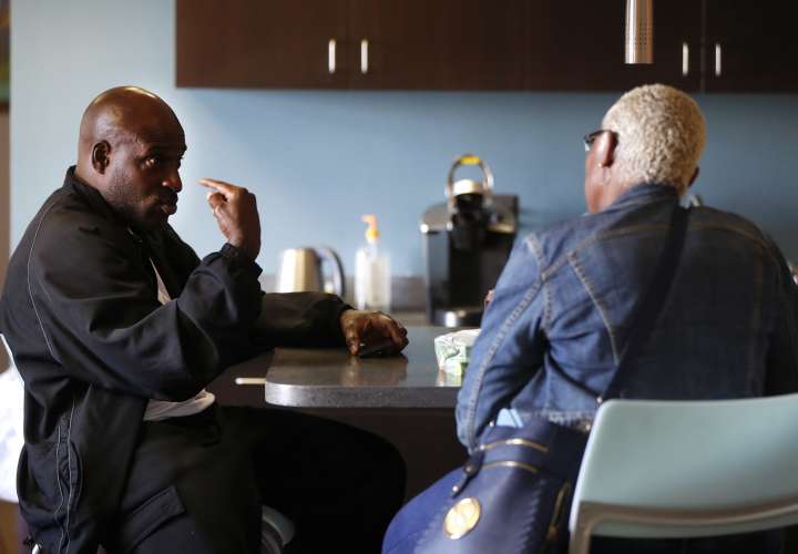 Bobby Hines, izquierda, habla con Valencia Warren-Gibbs sobre la muerte de su hermano, James, en la oficina de su abogado en Detroit. /  AP