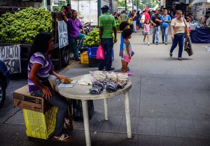 vendedora informal mientras espera por clientes en un puesto en una calle de Caracas (Venezuela). EFE