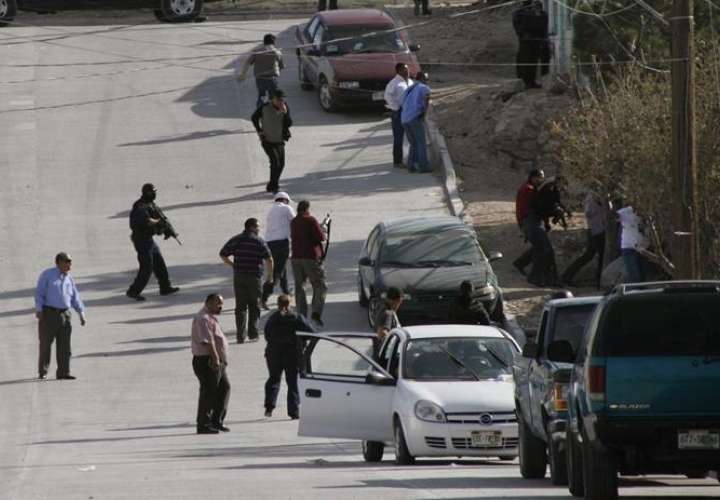 Agentes federales resguardan la zona en donde tres agentes fueron atacados por un grupo armado en la mexicana Ciudad Juárez. EFE/Archivo