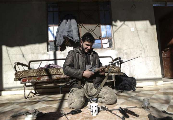 En la imagen, un soldado del Ejército del Islam (Jaysh al-Islam) limpiando su arma en la localidad de Duma, controlada por los rebeldes, a las afueras de Damasco, Siria. EFEArchivo