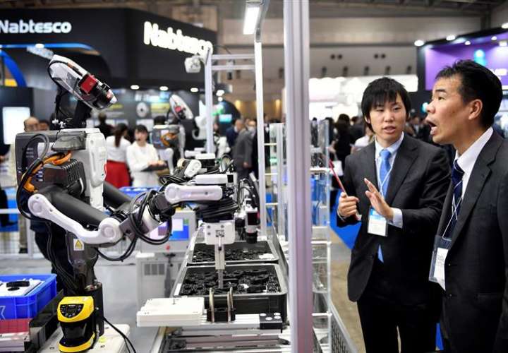Un par de asistentes observan un robot industrial en el stand de THK en la Feria Internacional de la Robótica en Tokio (Japón) hoy, 29 de noviembre de 2017. Más de 600 compañías y organizaciones presentarán sus novedades hasta el 2 de diciembre. EFE