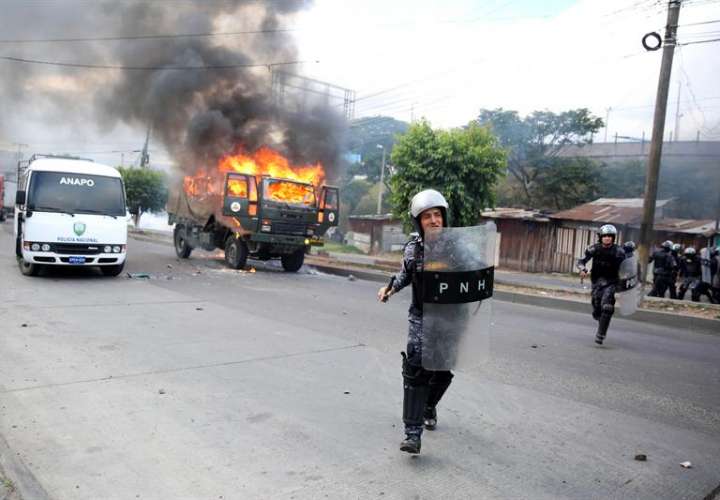 Decenas de policías hondureños se enfrentan con un grupo de manifestantes hoy, viernes 15 de diciembre de 2017, en Tegucigalpa (Honduras). EFE