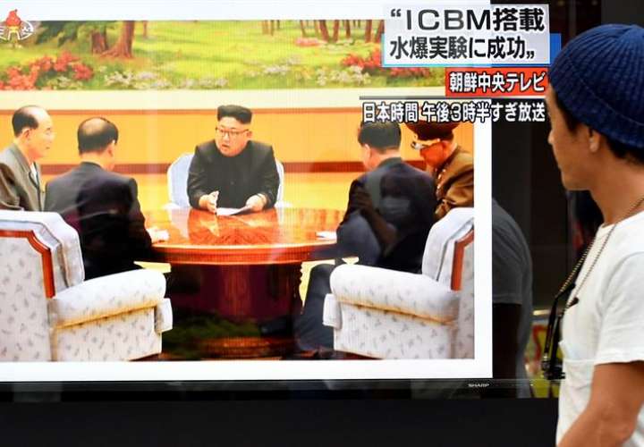 Un peatón pasa delante de una televisión en la que aparece la imagen del líder de Corea del Norte, Kim Jong-un (C). EFEArchivo