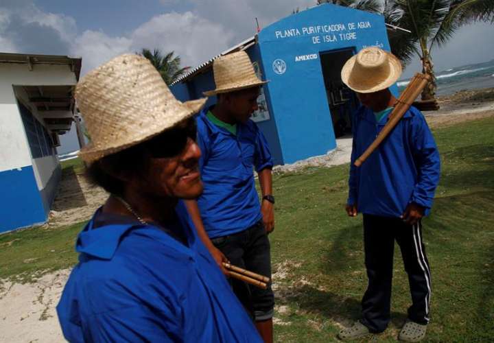 Un grupo de residentes indígenas de Isla Tigre de la Comarca de Guna Yala se reúnen frente a la planta de purificación de agua instalada por la Organización de las Naciones Unidas para la Alimentación y la Agricultura (FAO), en Isla Tigre (Panamá). EFE