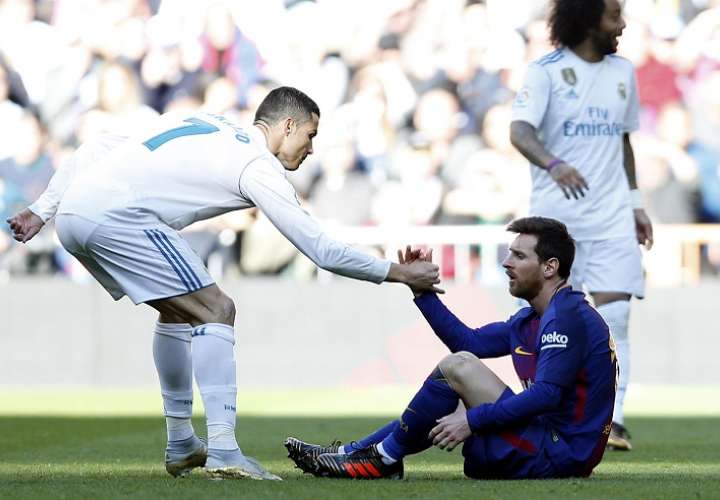 Cristiano Ronaldo ayuda a Leo Messi a recuperarse durante el partido de fútbol La Liga española. Foto: AP